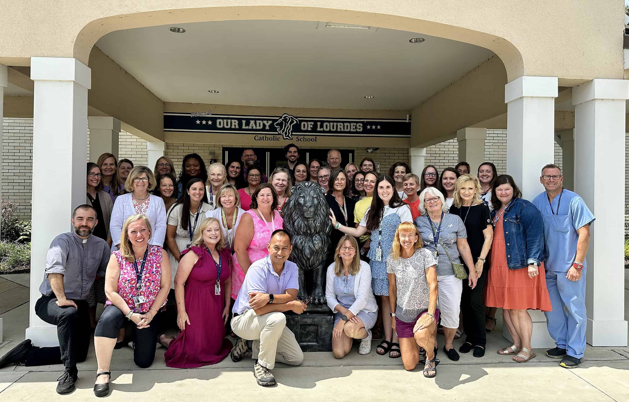 Lourdes faculty and staff in front of the school